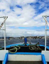 Boats moored at harbor against blue sky