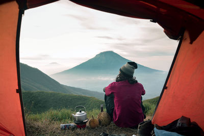 Rear view of man on mountain range against sky