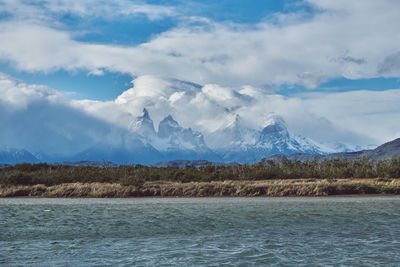 Scenic view of lake by mountains against sky