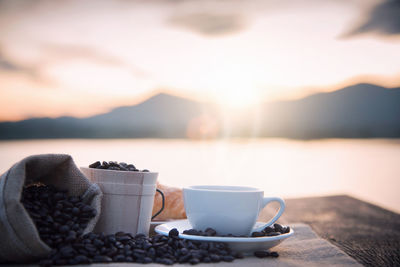 Close-up of coffee on table against sky during sunset