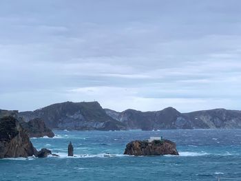 Scenic view of sea and mountains against sky