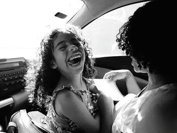 Close-up of happy young woman in car