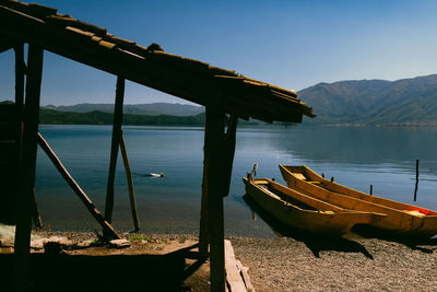 Boat moored on lake against clear sky