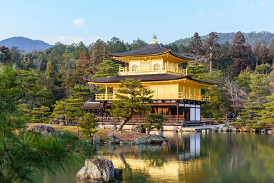 Building by lake against sky