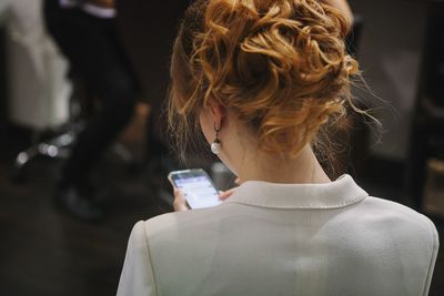 Rear view of woman using smart phone