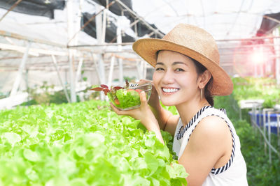 Portrait of smiling young woman holding hat