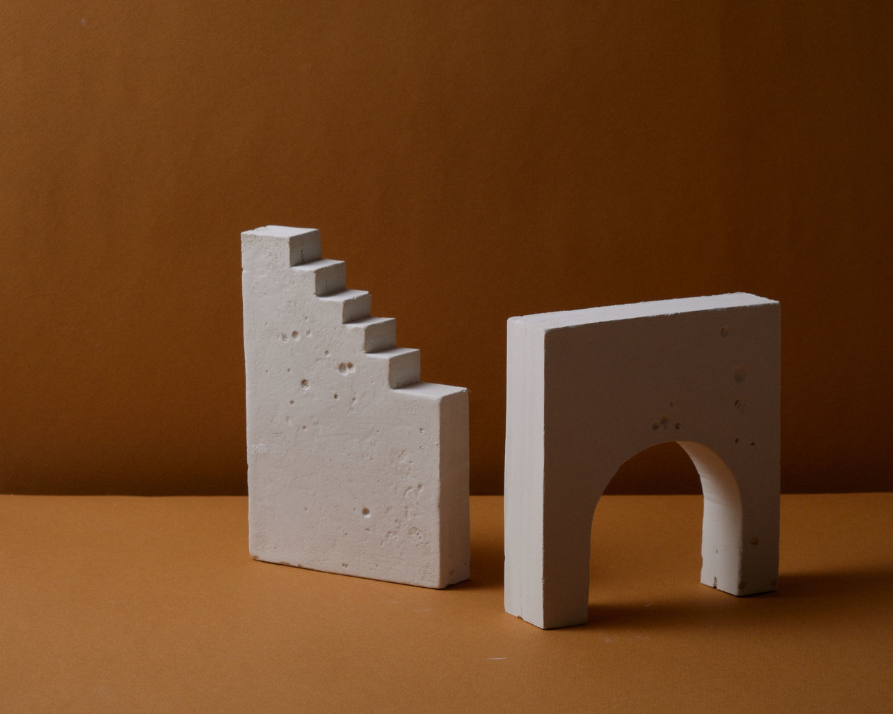 Close-up of gypsum cast shapes on table against wall