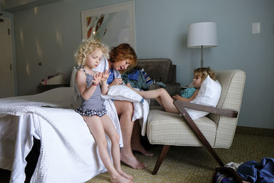 Grandmother painting granddaughter's toenails at home