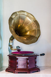 Close-up of metallic structure on table against wall