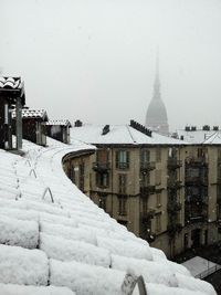 Snow covered buildings against sky