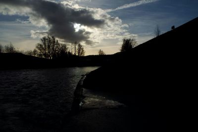 Scenic view of river against cloudy sky