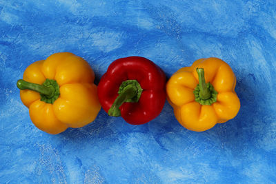 High angle view of bell peppers against blue background