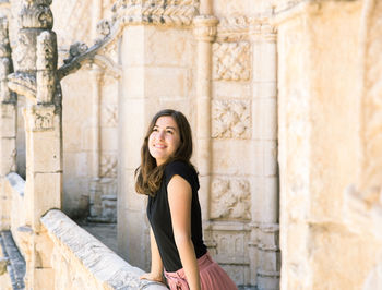 Full length of a young woman sitting outdoors