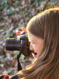 Close-up of girl photographing with camera