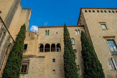 Low angle view of old building against clear blue sky