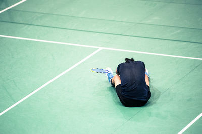 Rear view of tennis player sitting in court