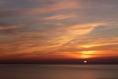 Scenic view of sea against romantic sky at sunset