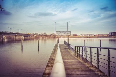 Pier over river against sky