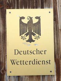 Close-up of information sign on wood