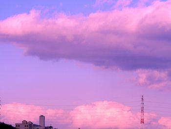 Low angle view of silhouette electricity pylon against sky during sunset