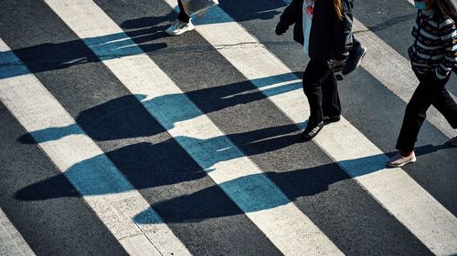 Low section of people walking on street crossing the road