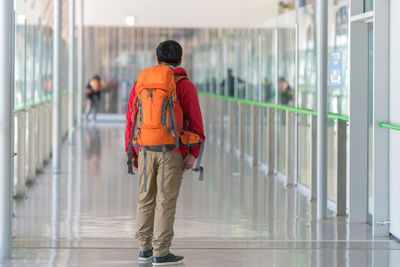 Rear view of man standing with backpack at airport