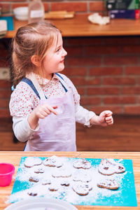 Full length of girl looking at table