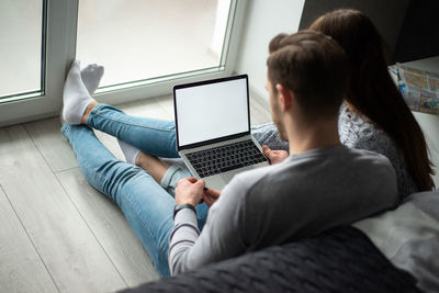 Rear view of man and woman using mobile phone