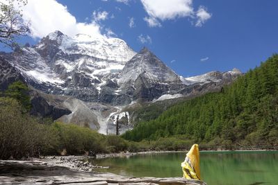 Scenic view of lake by snowcapped mountains against sky