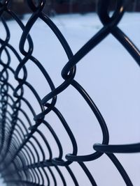 Close-up of chainlink fence against sky