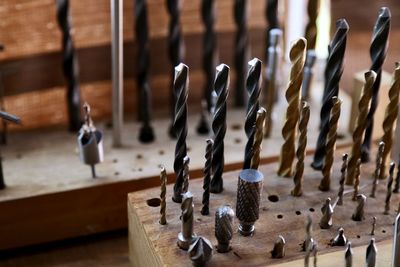 High angle view of drill bits in wood on table