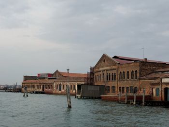 Houses by sea against sky