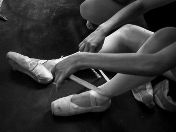 Low section of woman wearing ballet shoes