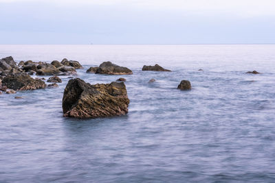 Rocks in sea against sky