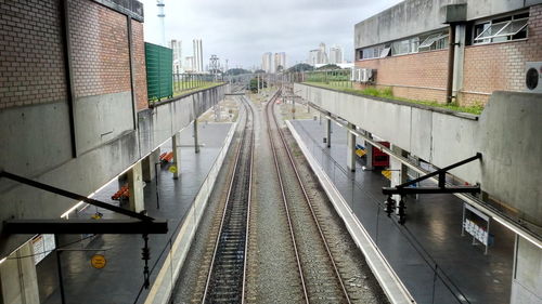 Railroad tracks in city against sky