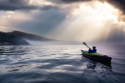 People on boat in sea against sky