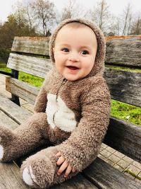 Portrait of cute baby boy wearing costume while sitting on bench