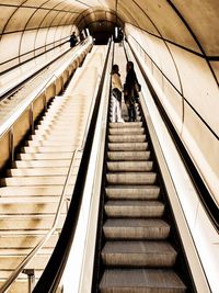 Low angle view of people standing on escalator