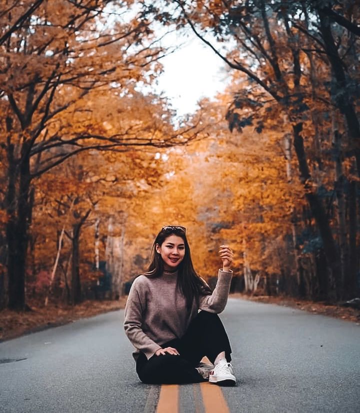 autumn, tree, one person, adult, leaf, plant part, women, nature, young adult, plant, clothing, beauty in nature, lifestyles, portrait, smiling, full length, road, leisure activity, sitting, long hair, emotion, happiness, city, hairstyle, looking at camera, orange color, tranquility, forest, female, outdoors, relaxation, tranquil scene, fashion, spring, front view, autumn collection, exercising, day, transportation, casual clothing, winter, land