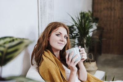 Portrait of a young woman drinking coffee