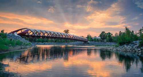 Bridge over river against sky during sunset