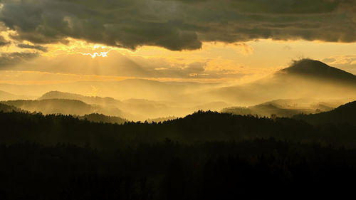 Scenic view of silhouette mountains against sky during sunset