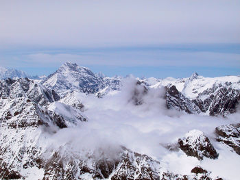 Scenic view of snow covered mountains against sky