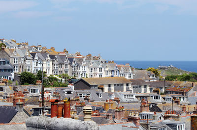 Houses by sea against sky in town