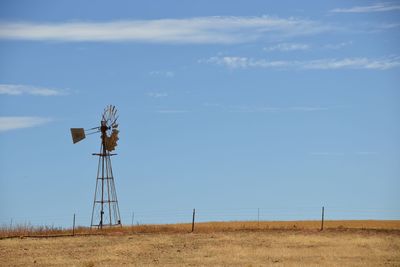 Windmill on field against sky