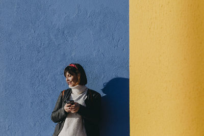 Woman standing against wall