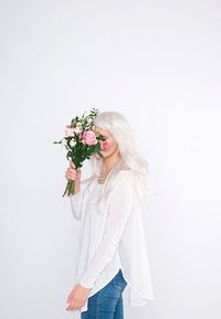 Young woman standing against white background