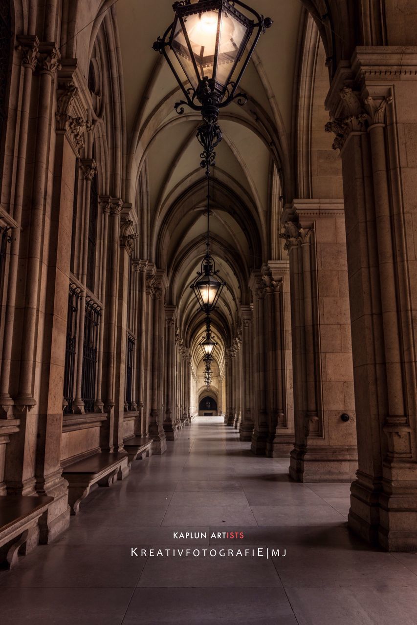 indoors, architecture, corridor, the way forward, built structure, diminishing perspective, arch, ceiling, architectural column, in a row, colonnade, column, empty, vanishing point, lighting equipment, illuminated, history, flooring, incidental people, architectural feature