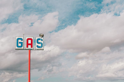 Low angle view of road sign against cloudy sky