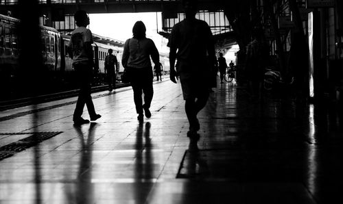 Silhouette people walking on railroad station